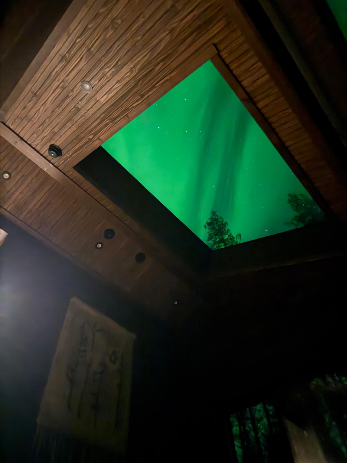 Northern lights through the skylight above the bed