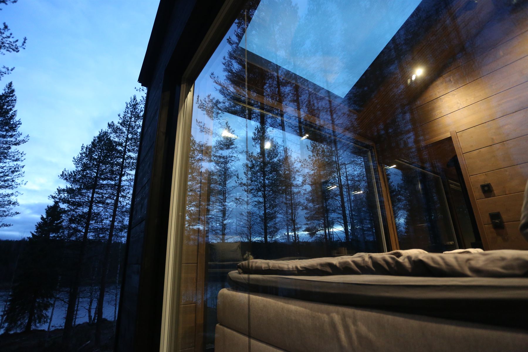 The bedroom seen through the glass wall, with the skylight above the bed